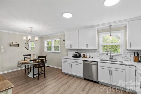 a kitchen with a table chairs sink and cabinets