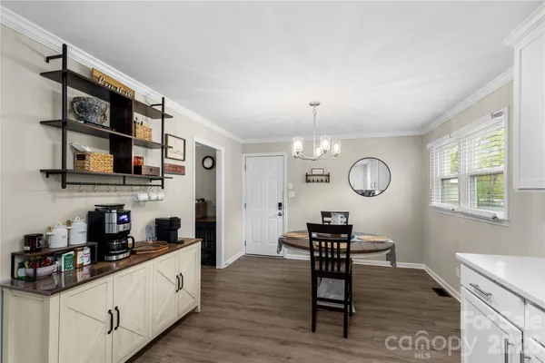 a living room with stainless steel appliances kitchen island granite countertop furniture a rug and a window