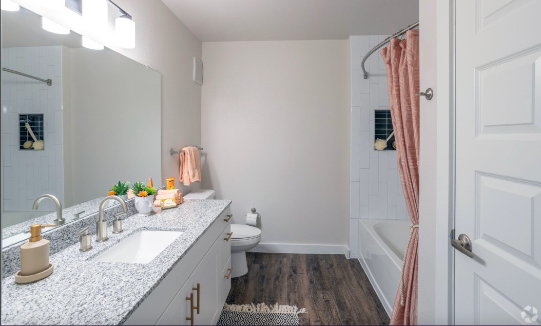 10010 North Capital Of Texas Highway Austin, TX 78759 - Photo 21 of 22 a bathroom with a granite countertop sink a toilet a mirror and shower