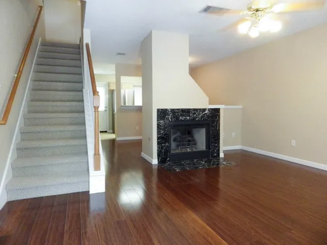 a view of a livingroom with wooden floor and a fireplace