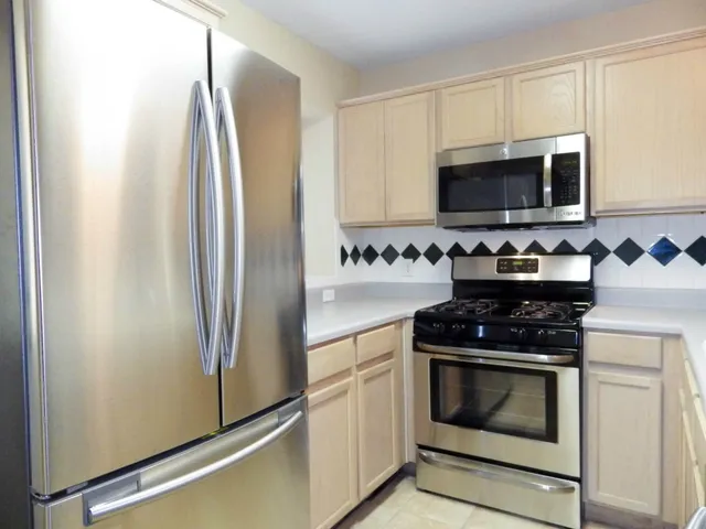 a kitchen with stainless steel appliances a refrigerator stove and microwave