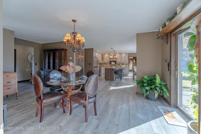 a kitchen with stainless steel appliances kitchen island granite countertop a table chairs in it and wooden floors