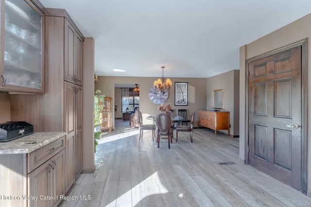 a view of a dining room with furniture a chandelier and large windows