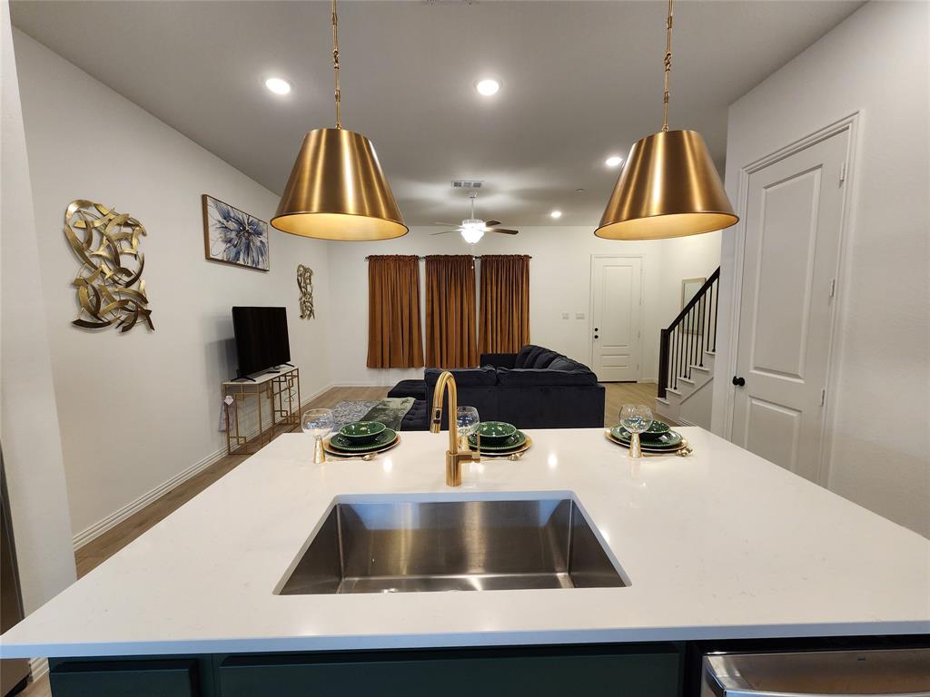 632 Blue Rdg Drive Mansfield, TX 76063 - Photo 2 of 16 a kitchen with kitchen island a sink a counter space and a view of living room