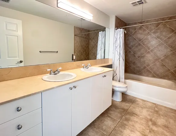 a spacious bathroom with a granite countertop sink toilet and shower
