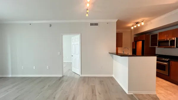 a view of a kitchen with wooden floor and a refrigerator