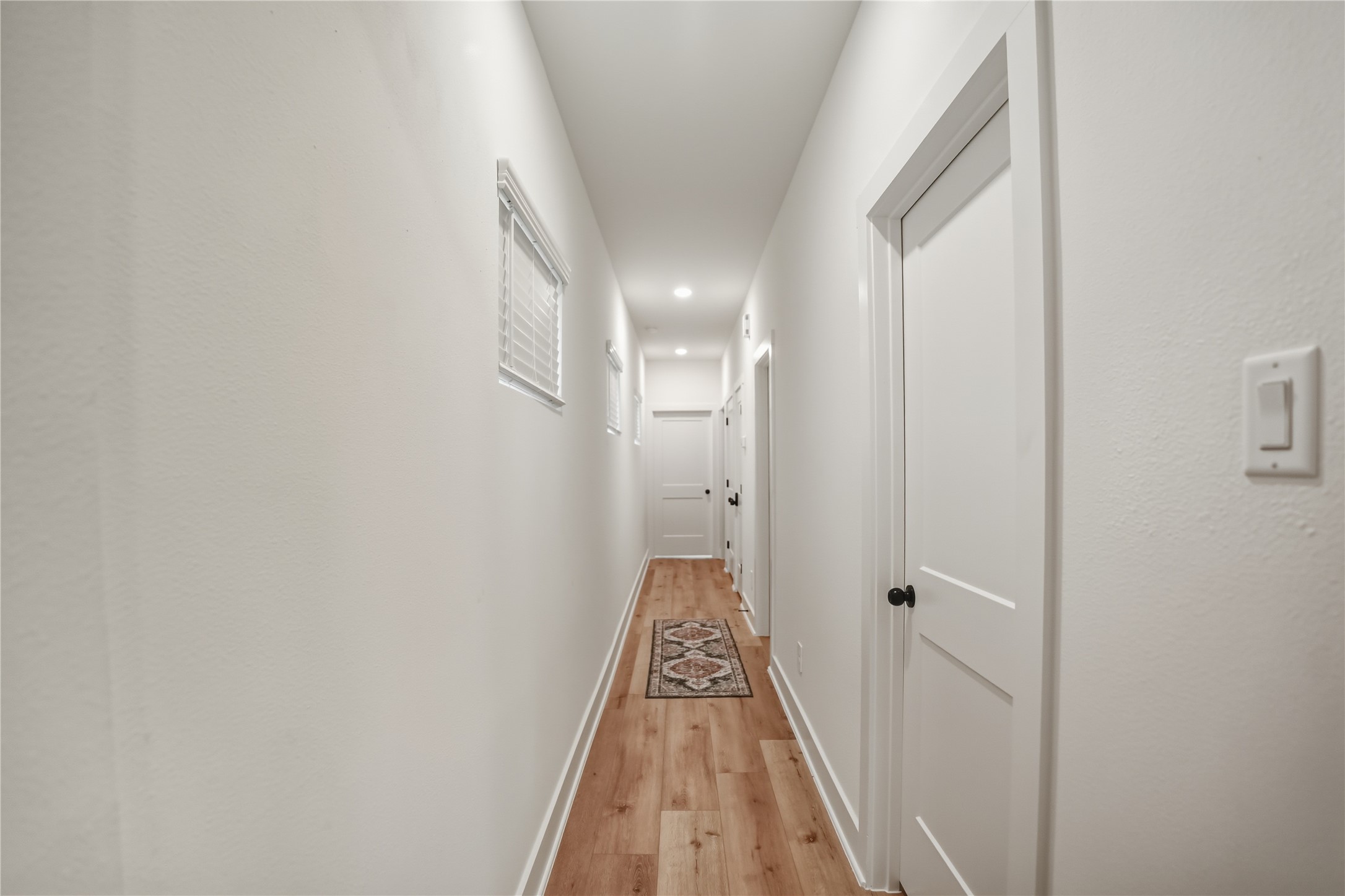 8017 B Cora Street Houston, TX 77088 - Photo 12 of 29 a view of a hallway with wooden floor and a bathroom
