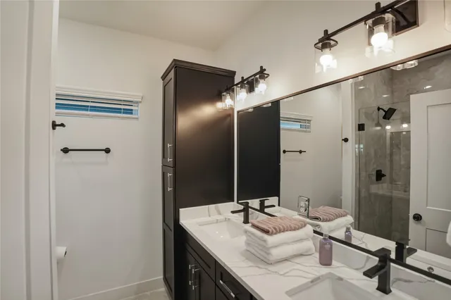 a bathroom with a sink vanity granite tub shower and mirror