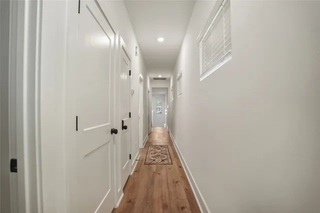 a view of a hallway with wooden floor and staircase