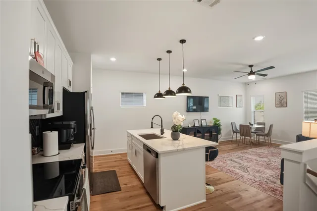 a kitchen with stainless steel appliances kitchen island granite countertop a sink and cabinets