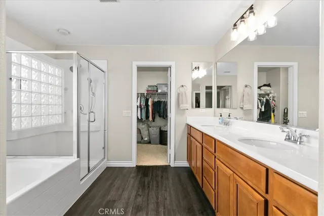 a bathroom with a double vanity sink a mirror a bathtub and shower