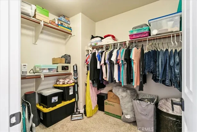 a view of walk in closet with clothes and shoes