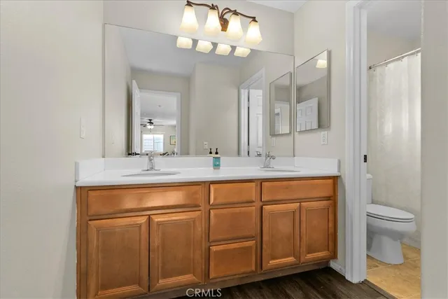 a bathroom with a granite countertop sink a toilet and a mirror