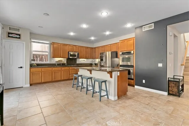 a kitchen with stainless steel appliances a sink a counter top space cabinets and a window