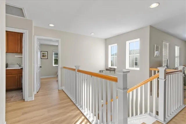 a view of a hallway with wooden floor and staircase