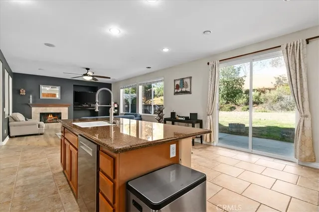 a dining hall with stainless steel appliances granite countertop a sink and a large window