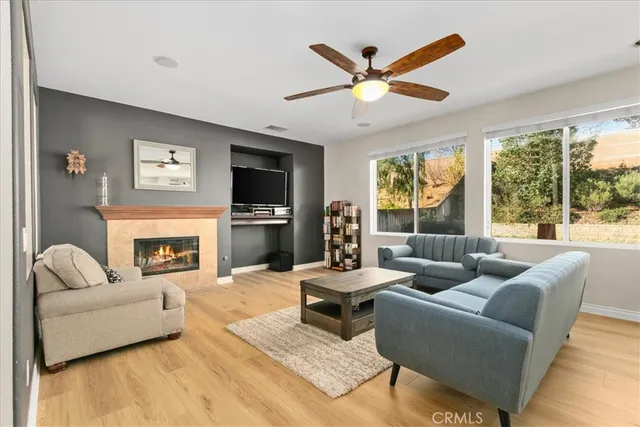 a living room with furniture a fireplace and a large window