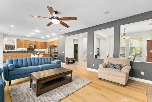 a living room with furniture kitchen view and a chandelier