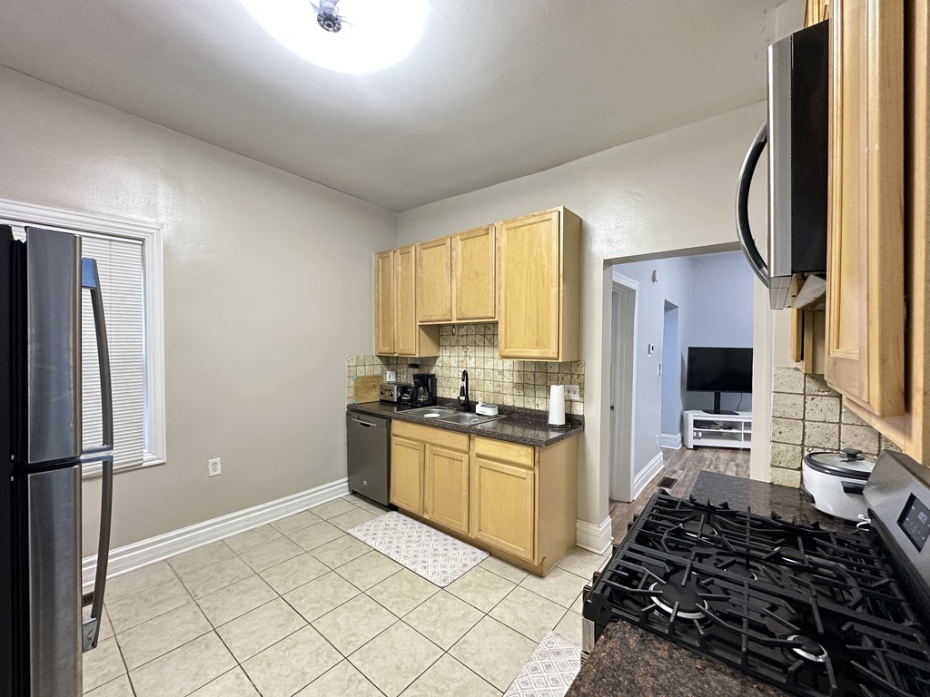 720 North Elizabeth Street, Unit 2 Chicago, IL 60642 - Photo 4 of 20 a kitchen with stainless steel appliances granite countertop a refrigerator stove top oven and sink
