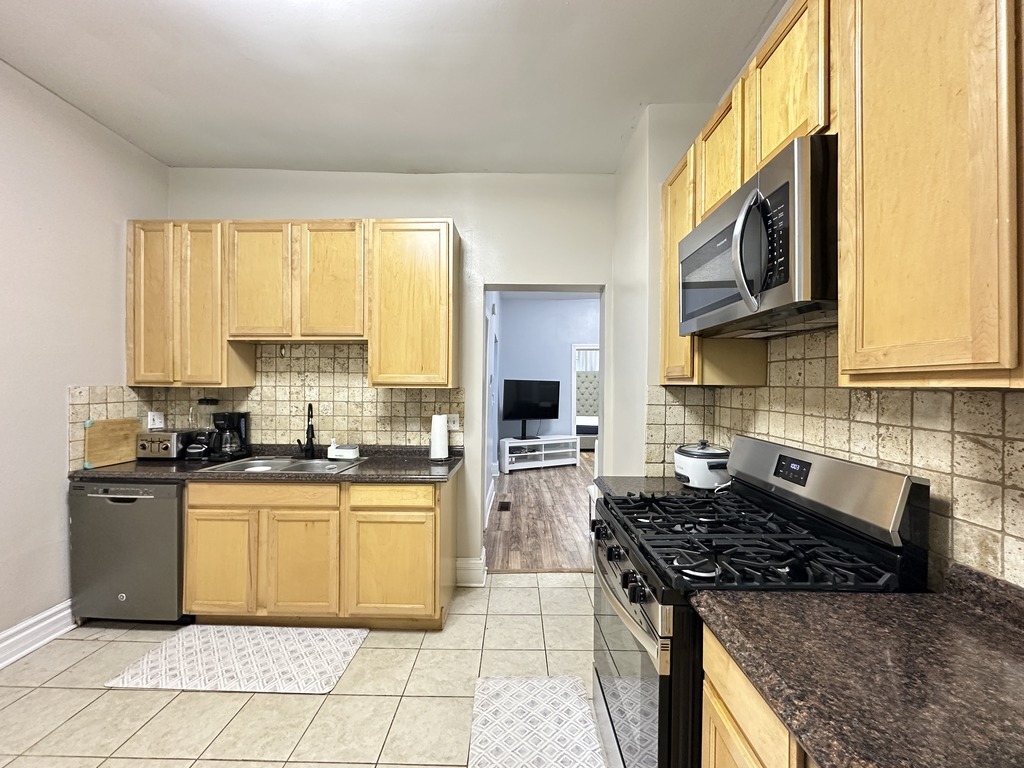 720 North Elizabeth Street, Unit 2 Chicago, IL 60642 - Photo 6 of 20 a kitchen with stainless steel appliances granite countertop a stove a sink and a microwave