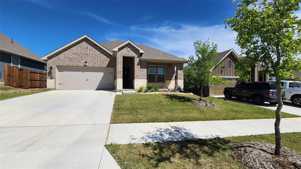 a view of a white house next to a yard with a large tree