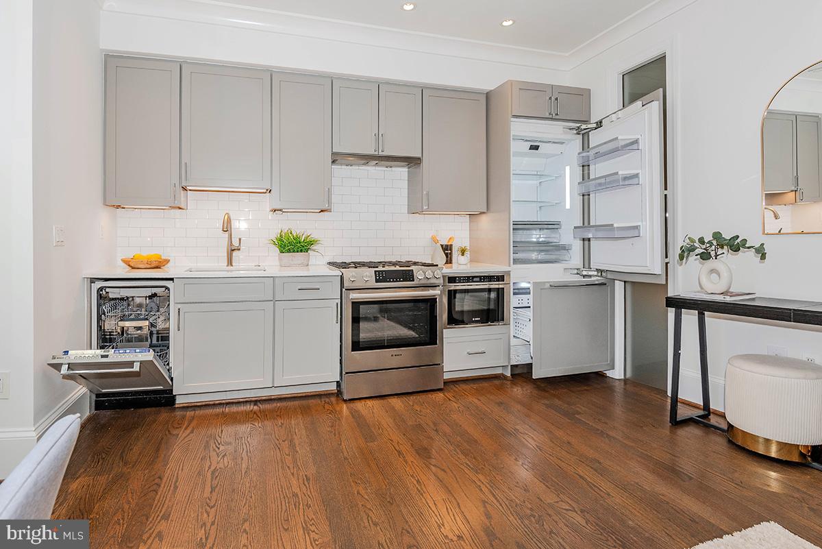 418 7th Street Southeast, Unit 302 Washington, DC 20003 - Photo 10 of 35 a kitchen with stainless steel appliances a stove a sink cabinets and a wooden floor