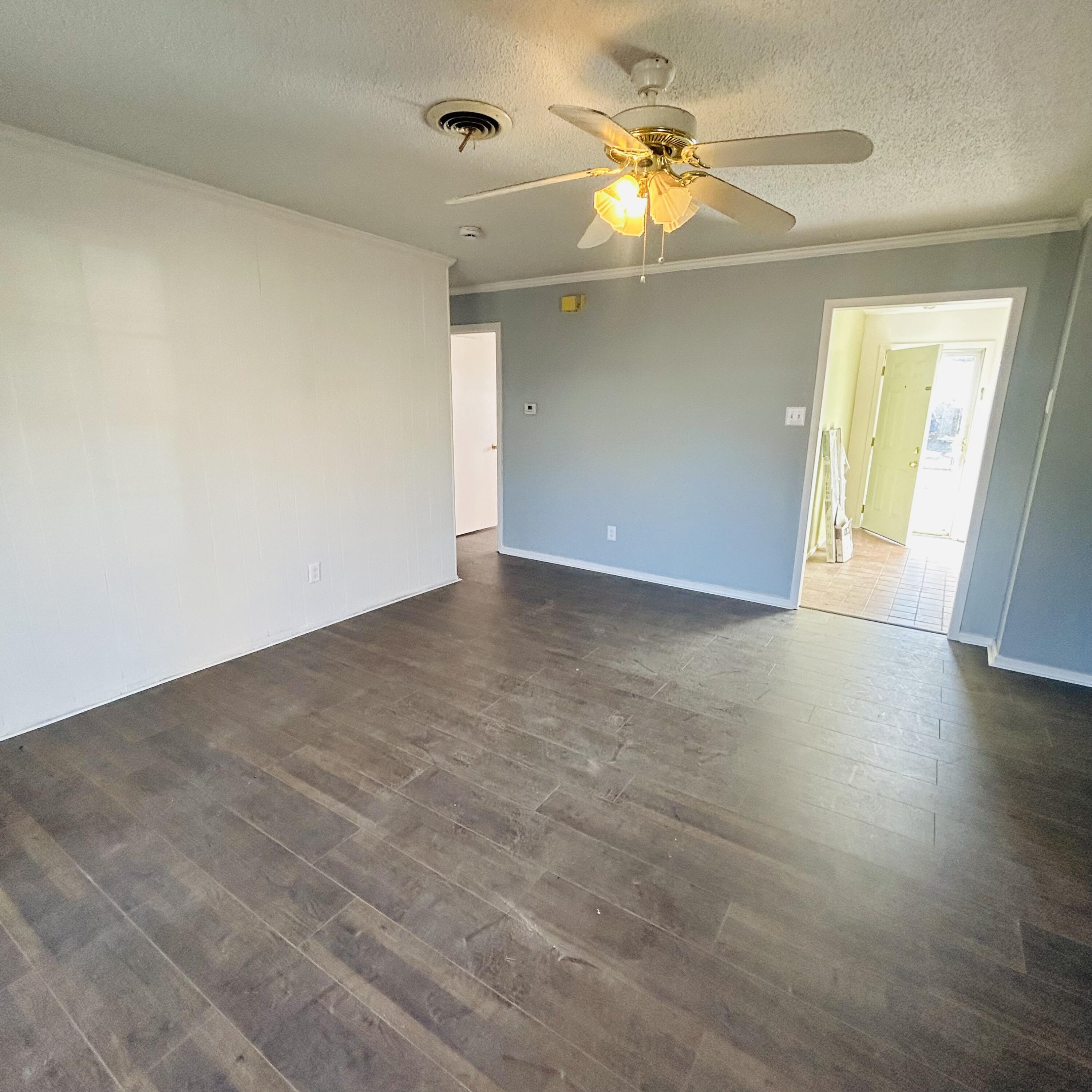 1918 71st Street Lubbock, TX 79412 - Photo 18 of 25 an empty room with a ceiling fan and wooden floor