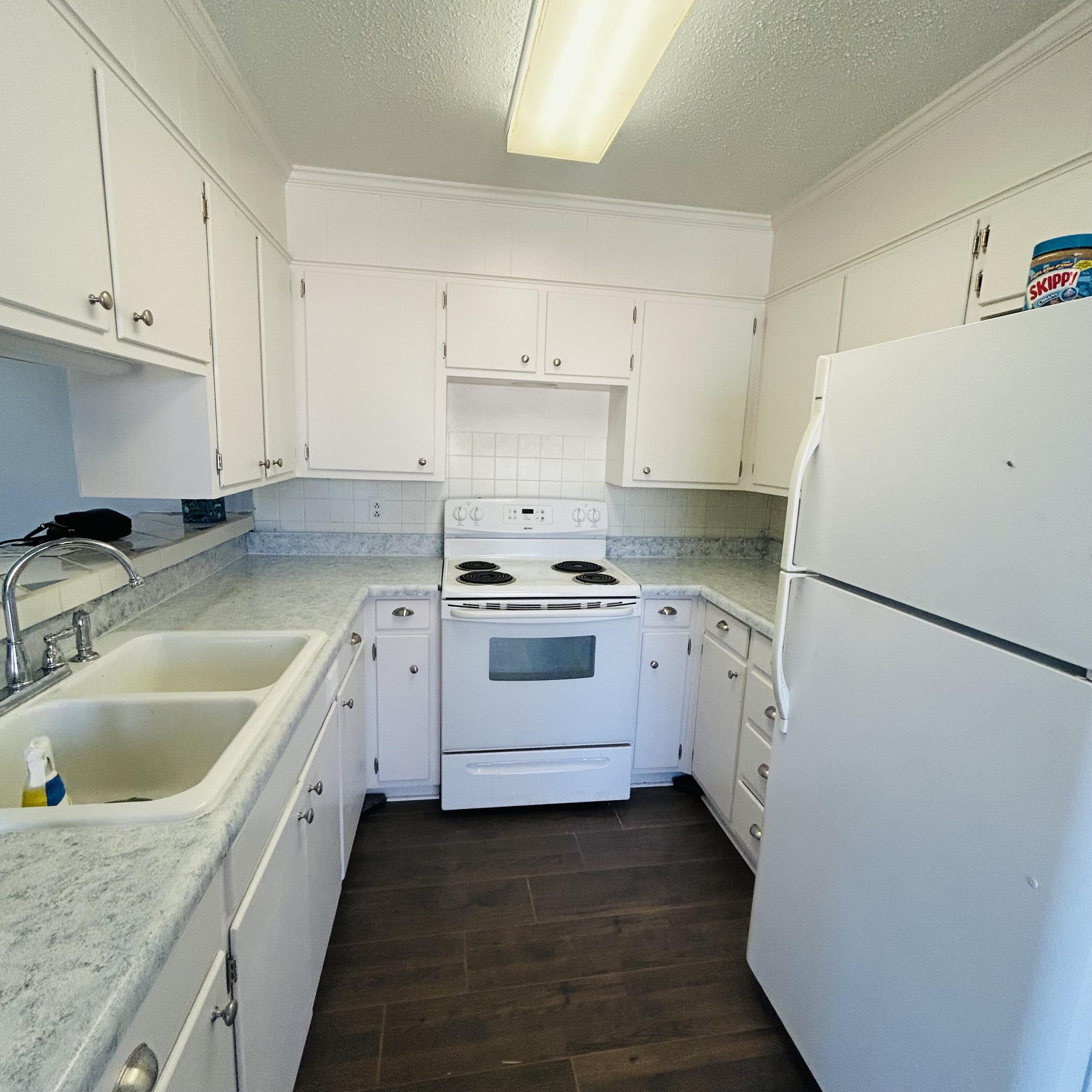 1918 71st Street Lubbock, TX 79412 - Photo 2 of 25 a kitchen with a white cabinets and white appliances