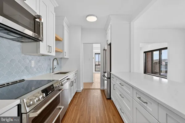 a kitchen with stainless steel appliances a sink stove top oven and cabinets