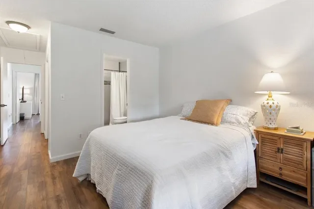 a bedroom with a bed and wooden floor