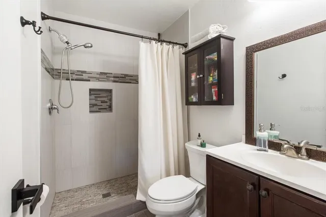 a bathroom with a granite countertop sink toilet and shower