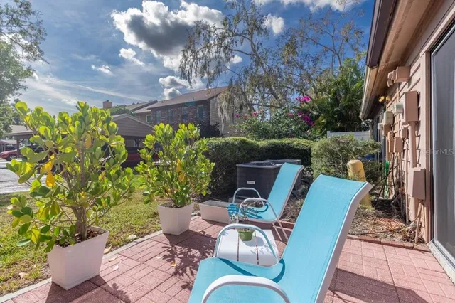a view of a patio with couches table and chairs and potted plants