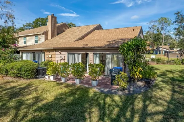 a view of a house with a yard and potted plants