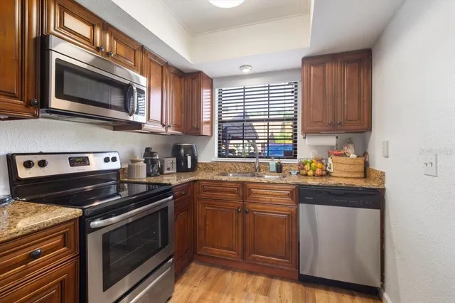 a kitchen with stainless steel appliances a stove a sink and a microwave