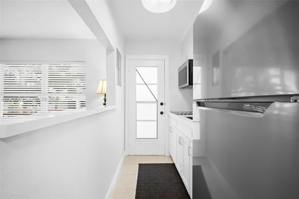 a kitchen with stainless steel appliances a microwave a sink and white cabinets