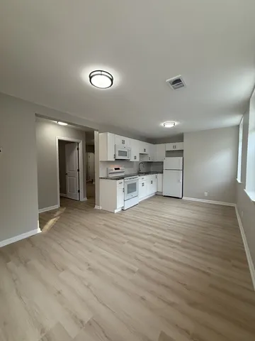 a view of a kitchen with a sink and a refrigerator