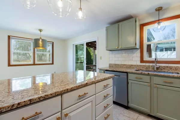 a kitchen with granite countertop cabinets stainless steel appliances a sink and a window