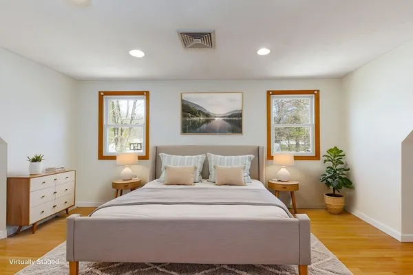 a bedroom with a bed and wooden floor