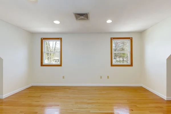 a view of empty room with window and wooden floor