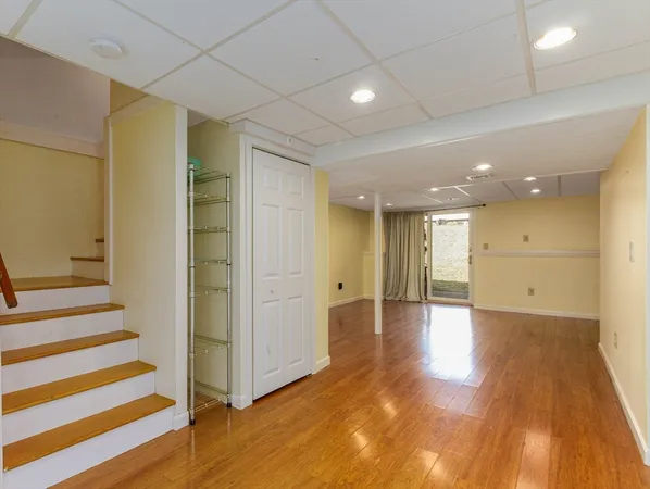 a view of a hallway with wooden floor and windows