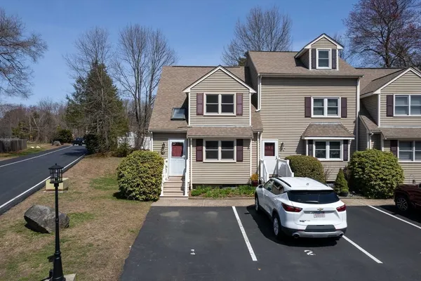 a front view of a house with a garden and parking space