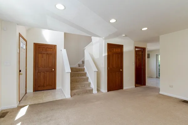 a view of hallway with closet and white walls