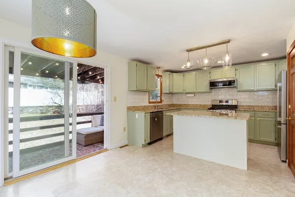 a kitchen with stainless steel appliances granite countertop a stove a sink and a refrigerator