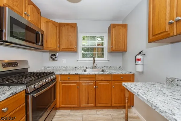 a kitchen with stainless steel appliances granite countertop a sink stove and microwave