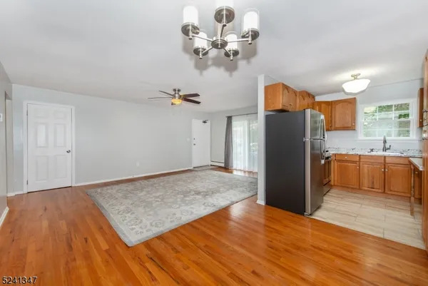 a view of a kitchen with wooden floor and a refrigerator