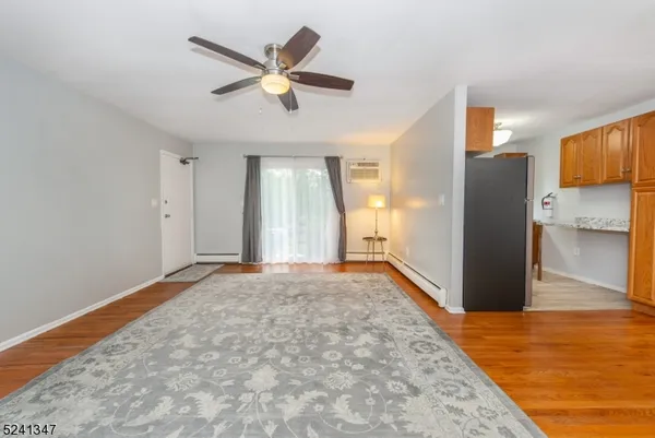 an empty room with wooden floor and a ceiling fan
