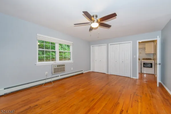 a view of empty room with wooden floor and window