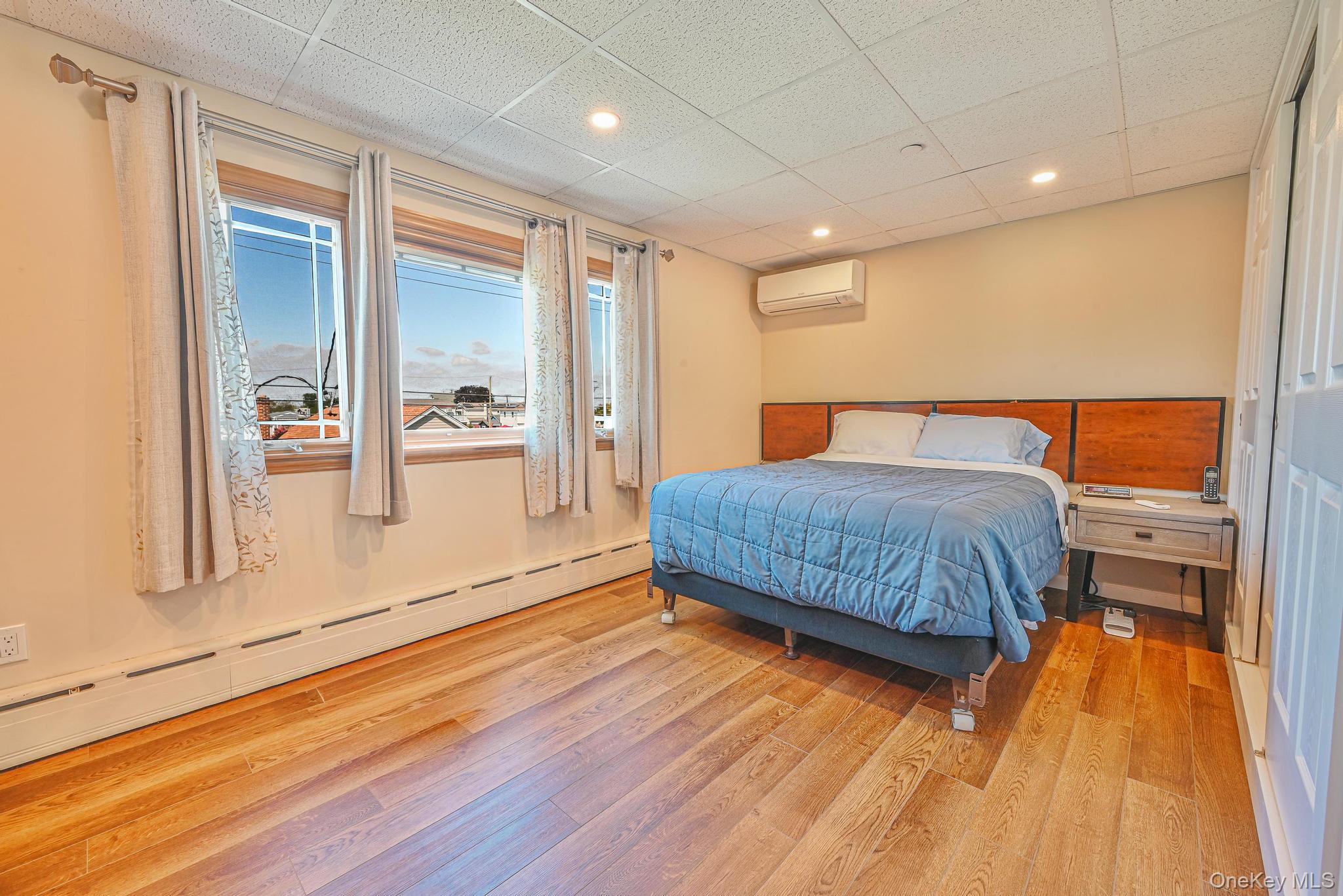 20 West 18th Road Queens, NY 11693 - Photo 32 of 41 a bedroom with a bed and wooden floor