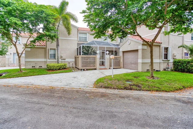 a front view of a house with a garden and trees