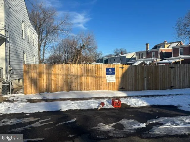 a view of backyard with wooden fence